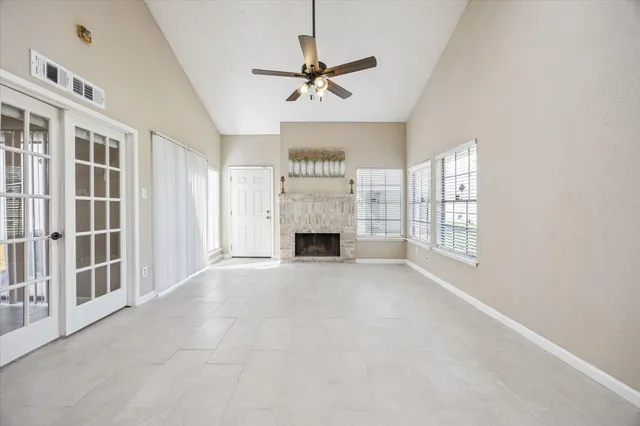 a view of an empty room with a fireplace and a window