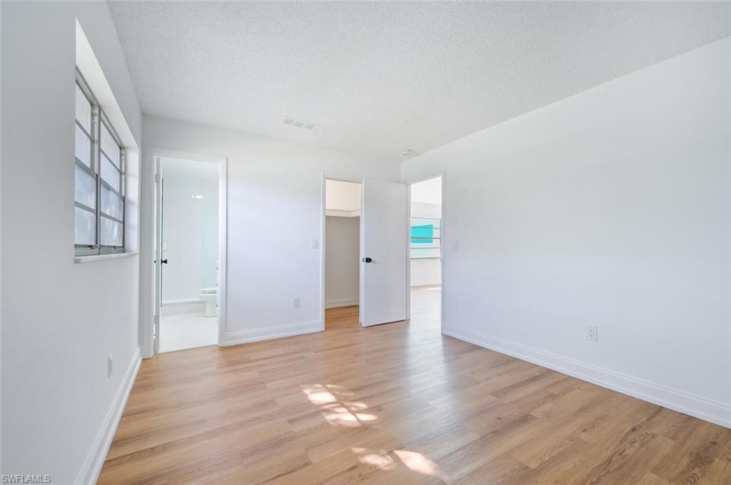 4666 Dorando Drive Naples, FL 34103 - Photo 17 of 30 a view of an empty room with wooden floor and a window