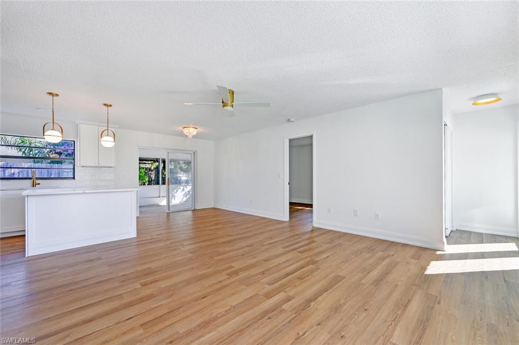 4666 Dorando Drive Naples, FL 34103 - Photo 7 of 30 a view of an empty room with wooden floor and a window
