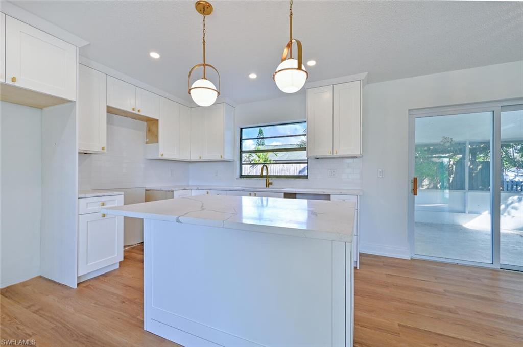 4666 Dorando Drive Naples, FL 34103 - Photo 8 of 30 a kitchen with stainless steel appliances granite countertop wooden cabinets a stove a sink and a wooden floor
