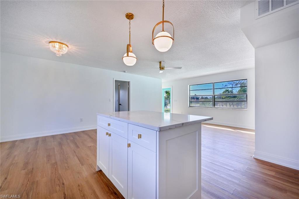 4666 Dorando Drive Naples, FL 34103 - Photo 10 of 30 a kitchen with wooden floor and window
