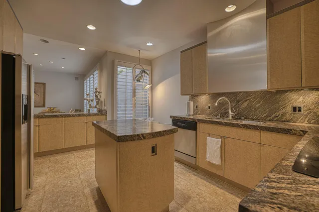 a kitchen with granite countertop a sink and cabinets