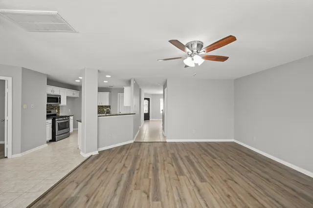 a view of a kitchen with wooden floor and a ceiling fan