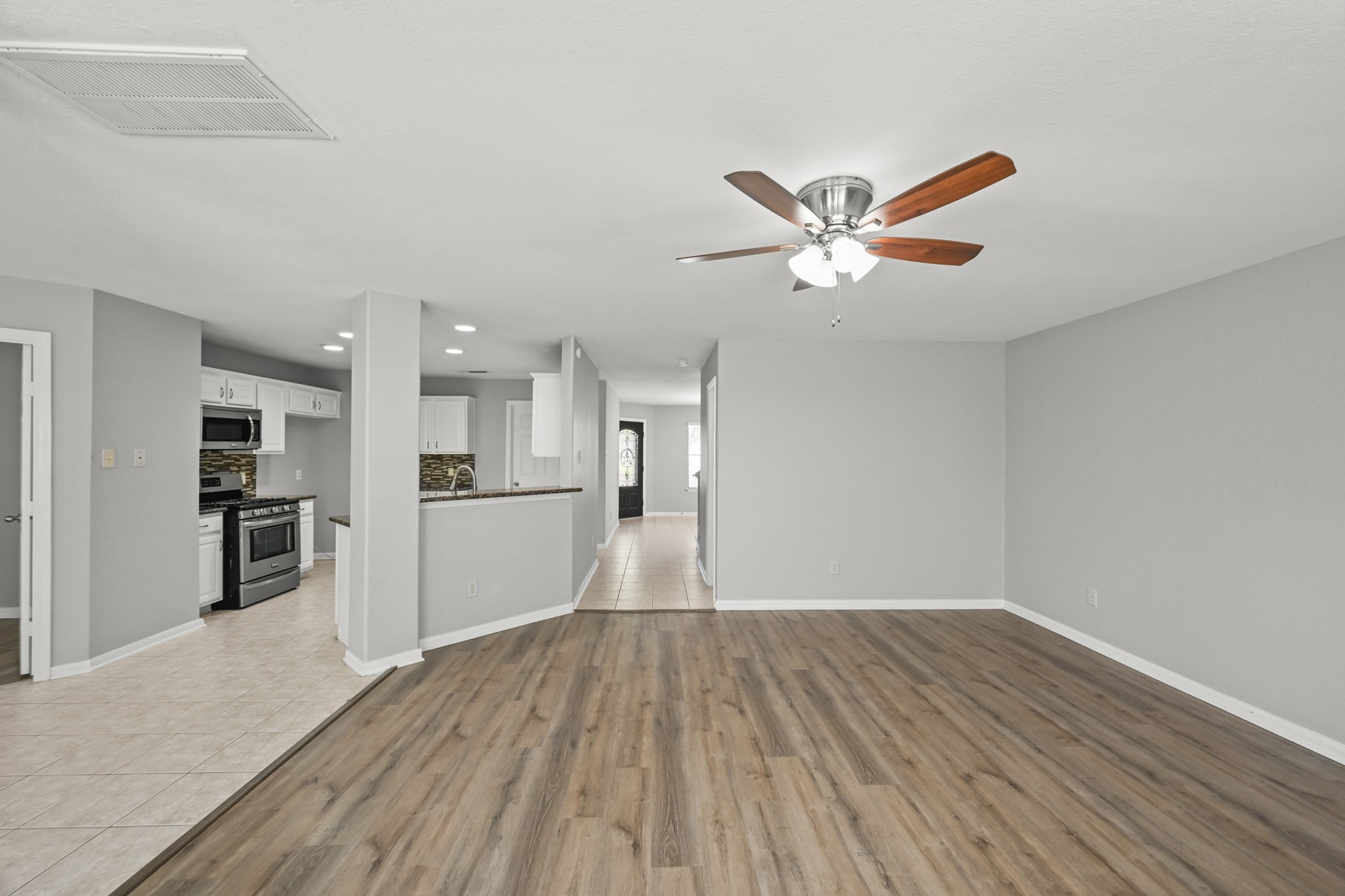 14614 Hazy Ridge Lane Cypress, TX 77429 - Photo 15 of 36 a view of a kitchen with wooden floor and a ceiling fan