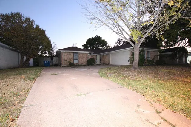a view of a house with a large tree and a yard