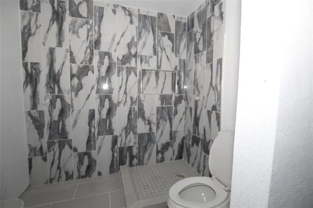 a bathroom with a toilet and a shower curtain
