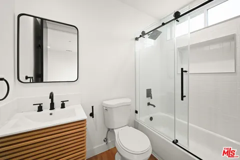 a bathroom with a sink toilet vanity and shower