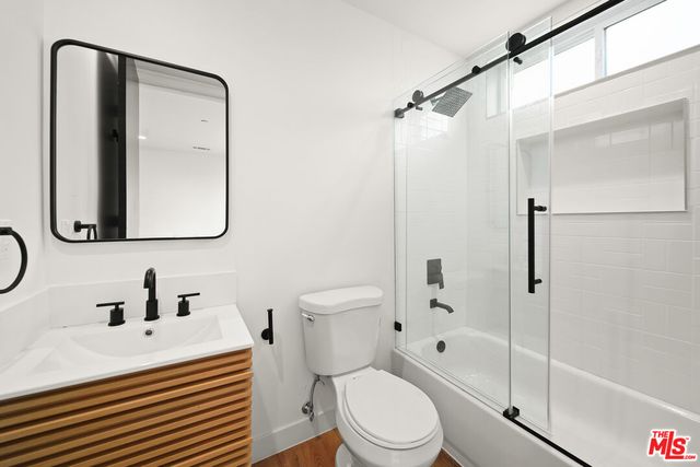 a bathroom with a sink toilet vanity and shower