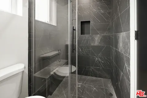 a bathroom with a toilet and a shower
