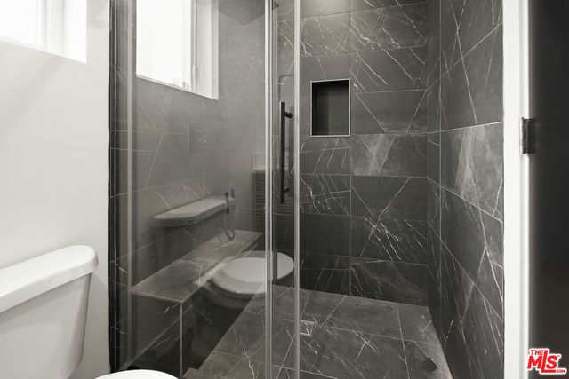 a bathroom with a toilet and a shower