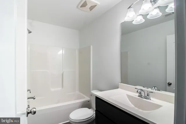 a bathroom with a sink a toilet a mirror and shower
