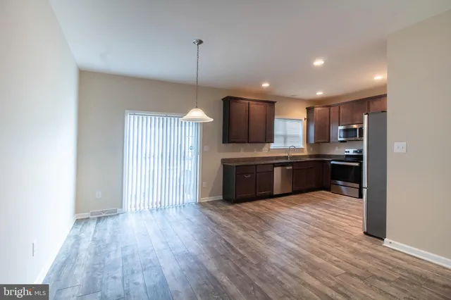 a kitchen with stainless steel appliances kitchen island granite countertop a stove a sink and a refrigerator