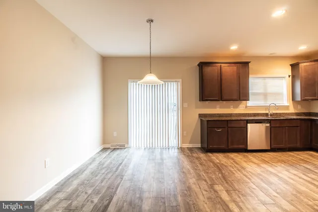 a open kitchen with a sink stove and wooden floor