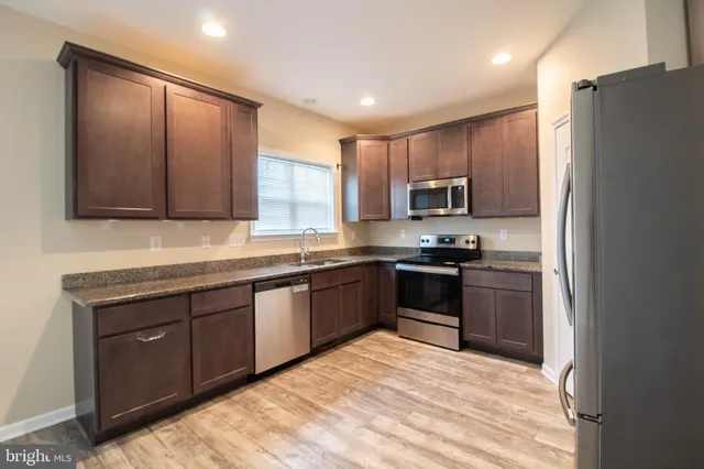 a kitchen with granite countertop stainless steel appliances and wooden cabinets