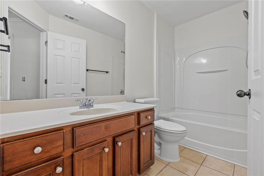 2615 Maple Leaf Terrace Cumming, GA 30041 - Photo 27 of 34 a bathroom with a sink a toilet and shower