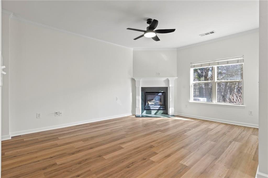 2615 Maple Leaf Terrace Cumming, GA 30041 - Photo 3 of 34 a view of an empty room with wooden floor fireplace and a window