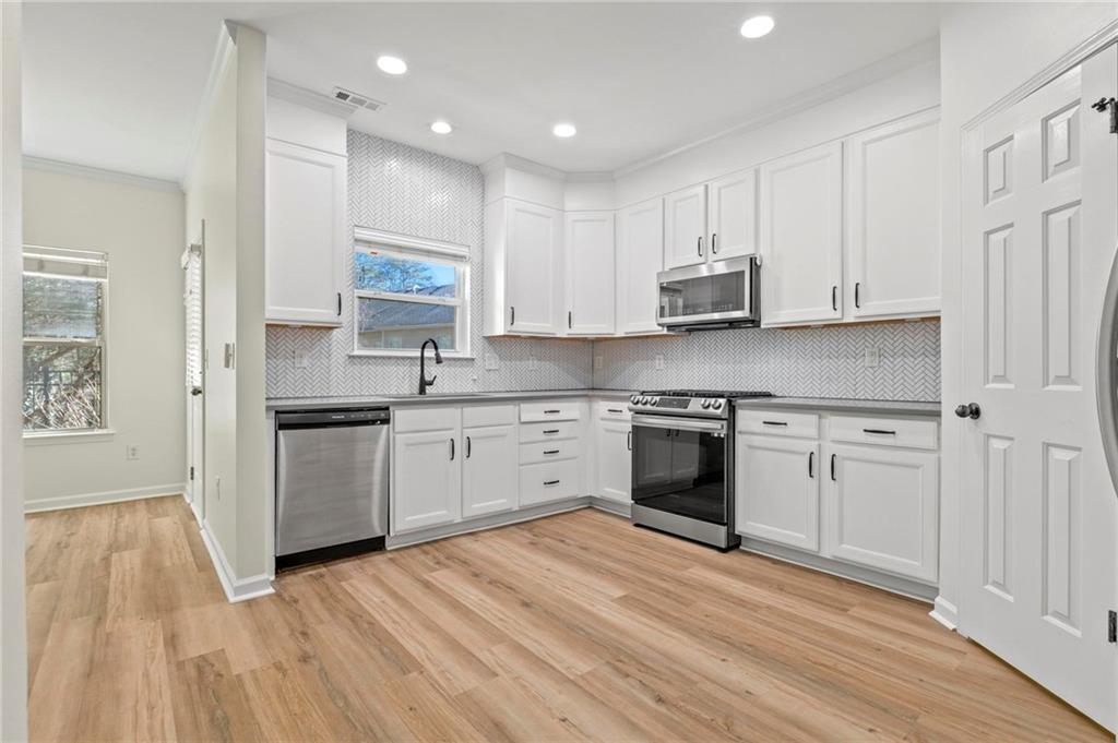 2615 Maple Leaf Terrace Cumming, GA 30041 - Photo 7 of 34 a kitchen with granite countertop white cabinets and white appliances