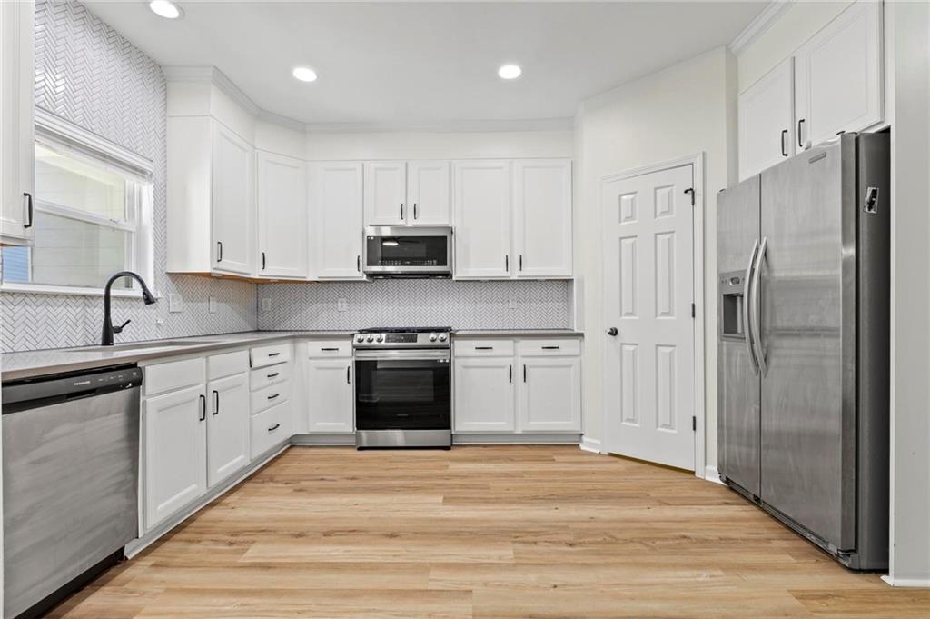 2615 Maple Leaf Terrace Cumming, GA 30041 - Photo 8 of 34 a kitchen with stainless steel appliances granite countertop a refrigerator and a stove top oven