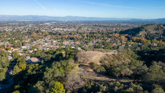 an aerial view of house with yard and mountain in the background