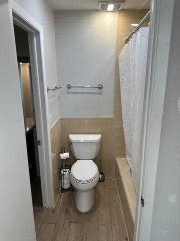 a bathroom with a toilet and a shower