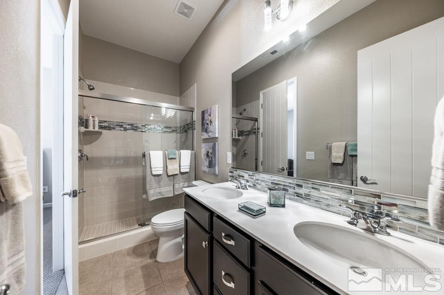 9826 Dyevera Lane Reno, NV 89521 - Photo 21 of 39 a bathroom with a double vanity sink toilet mirror and shower