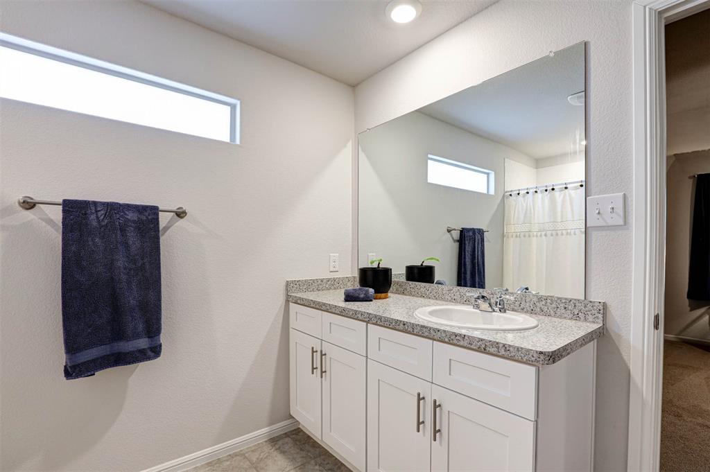512 Amory Street Azle, TX 76020 - Photo 15 of 25 a bathroom with a sink and a mirror