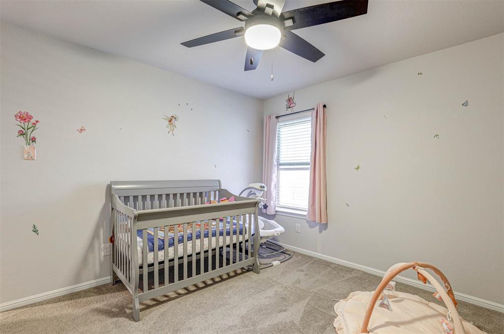 512 Amory Street Azle, TX 76020 - Photo 19 of 25 a bedroom with a bed and a chandelier