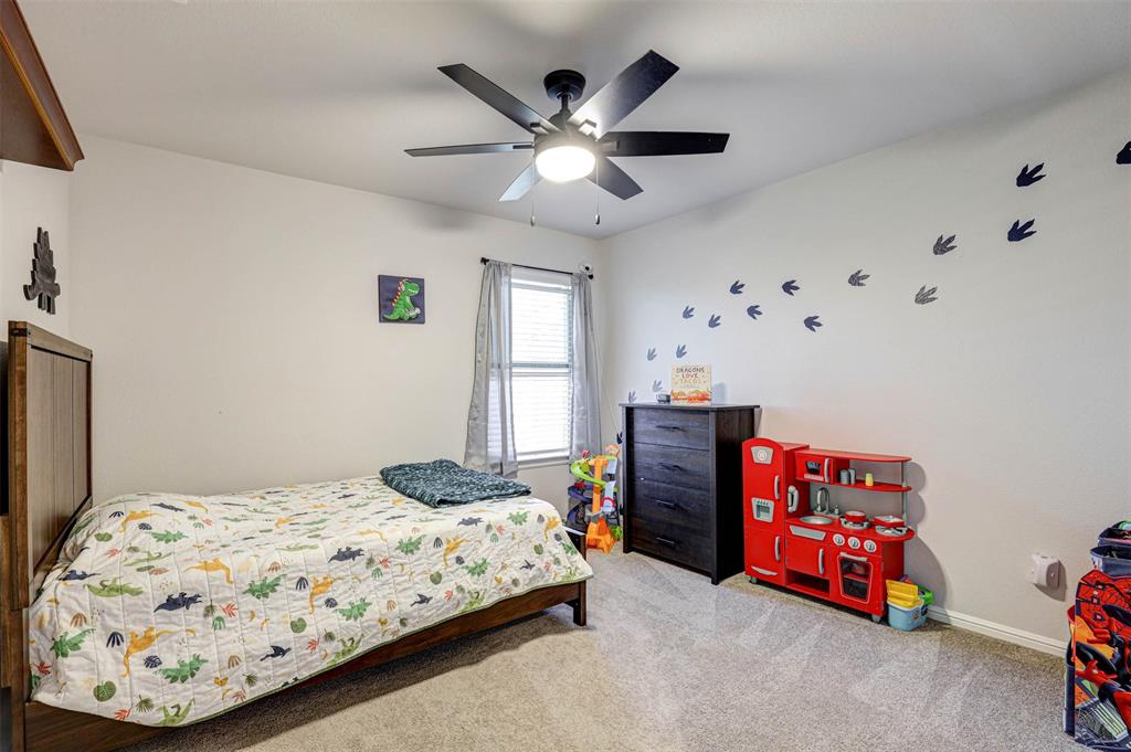 512 Amory Street Azle, TX 76020 - Photo 21 of 25 a bedroom with a bed and a chandelier
