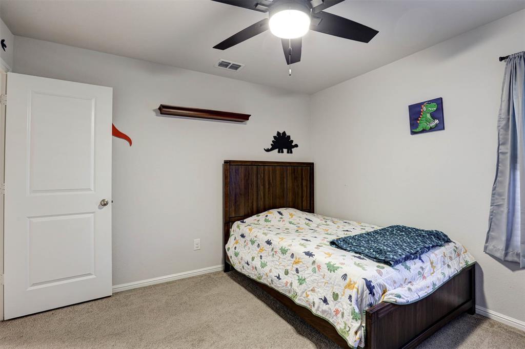 512 Amory Street Azle, TX 76020 - Photo 22 of 25 a bedroom with a bed and a chandelier