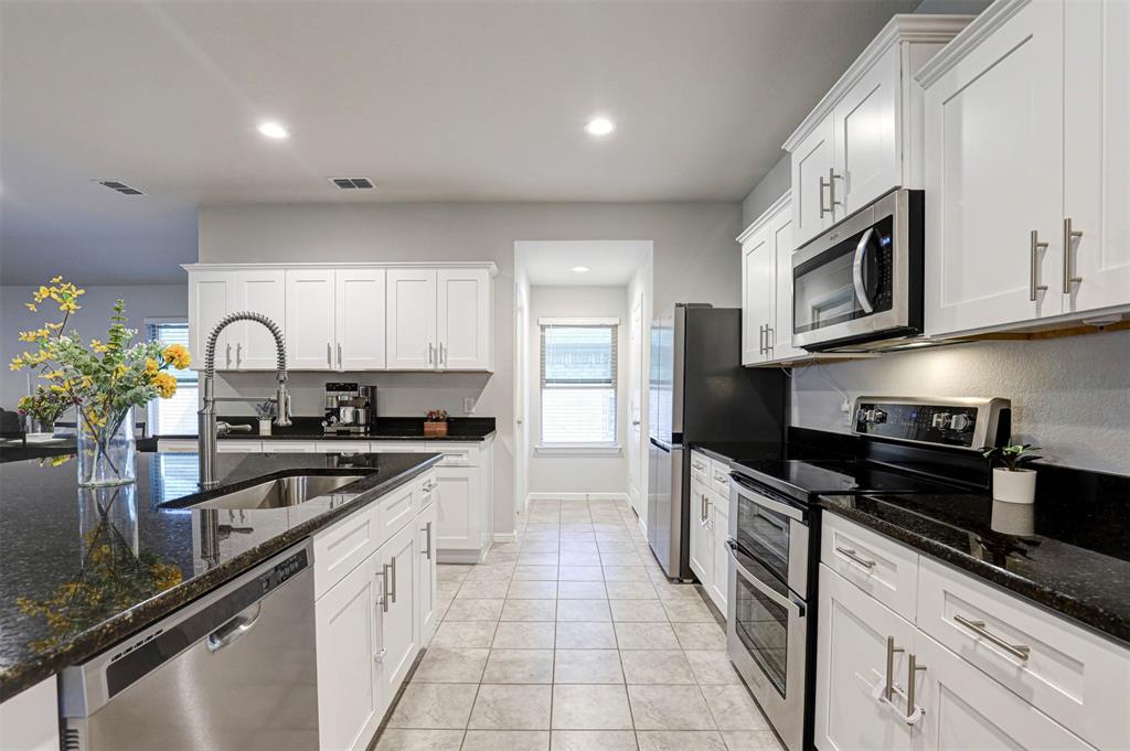 512 Amory Street Azle, TX 76020 - Photo 3 of 25 a kitchen with stainless steel appliances granite countertop a stove a sink and a microwave