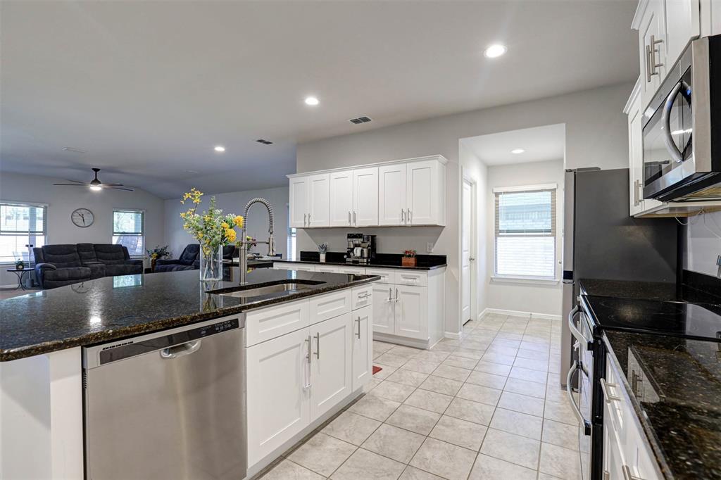 512 Amory Street Azle, TX 76020 - Photo 5 of 25 a kitchen with granite countertop a sink stainless steel appliances and cabinets