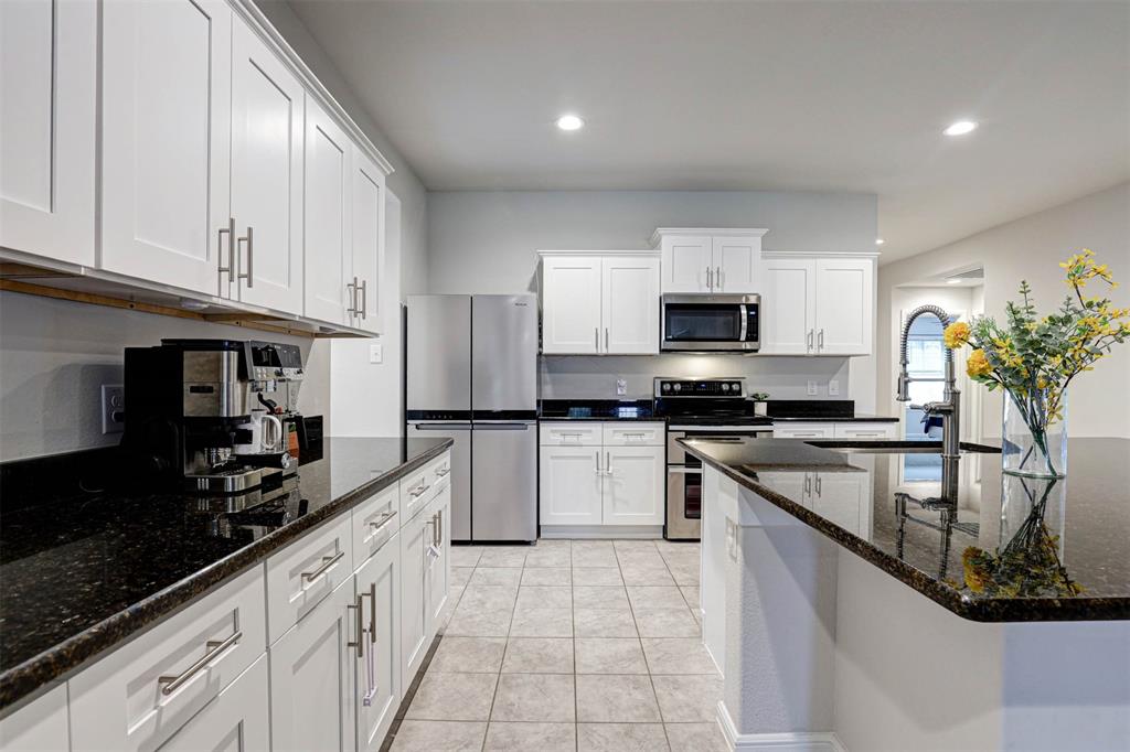 512 Amory Street Azle, TX 76020 - Photo 6 of 25 a kitchen with granite countertop white cabinets and stainless steel appliances