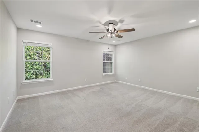 an empty room with a window and a fan