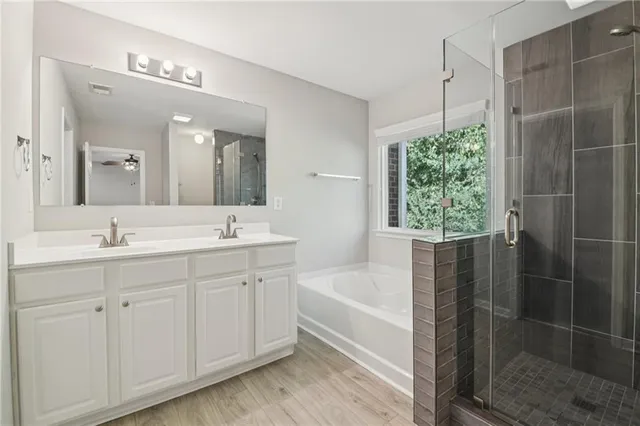 a bathroom with a tub sink and mirror