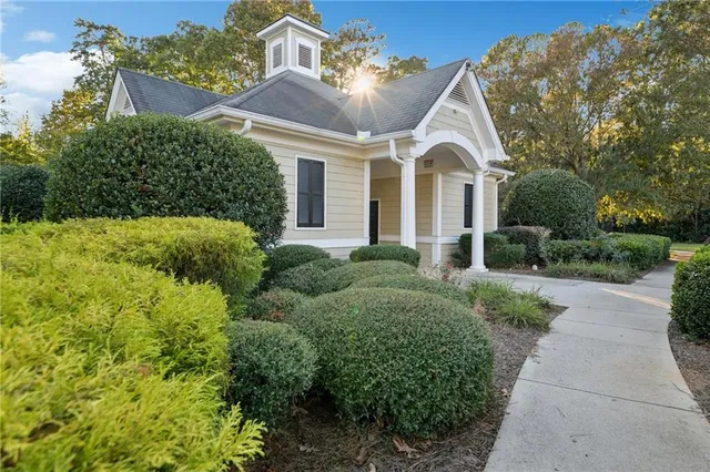 a view of a white house with a big yard and potted plants