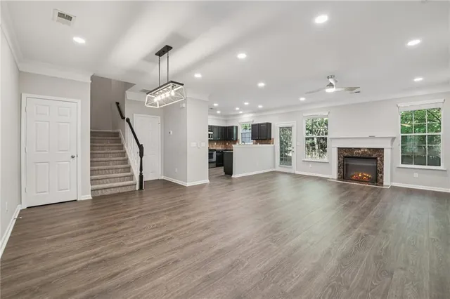 an empty room with wooden floor fireplace and windows