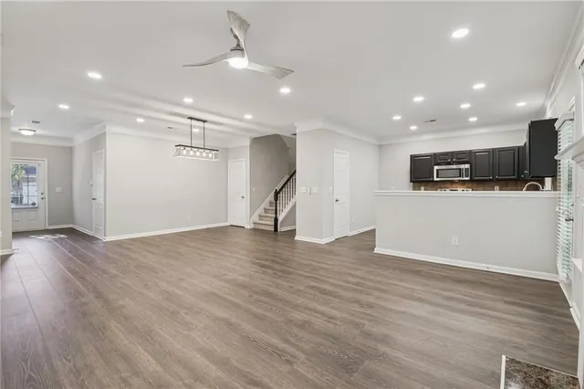 a view of a big room with wooden floor and a kitchen