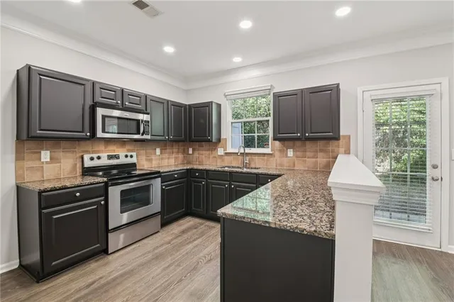 a kitchen with a stove sink and microwave
