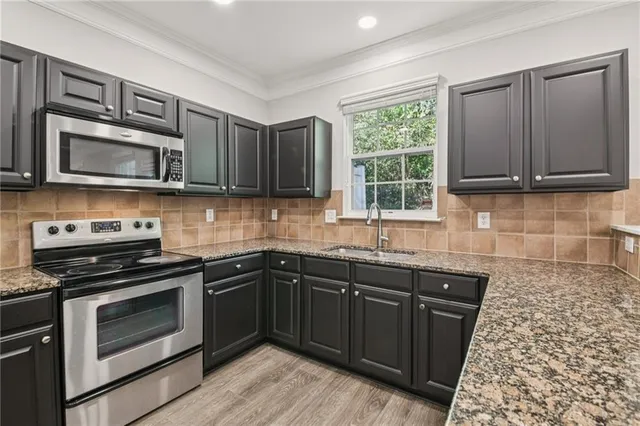 a kitchen with a sink stove and microwave