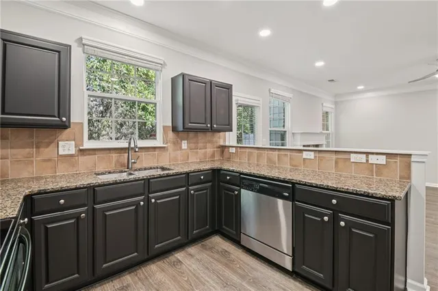 a kitchen with granite countertop stainless steel appliances sink a window and a counter top space