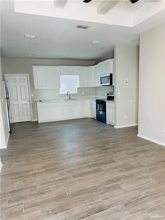 1614 Playa Drive, Unit 3 Weslaco, TX 78596 - Photo 2 of 11 a view of kitchen and empty room with wooden floor