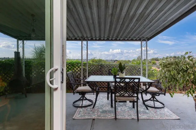 a view of an outdoor dining space with furniture and garden