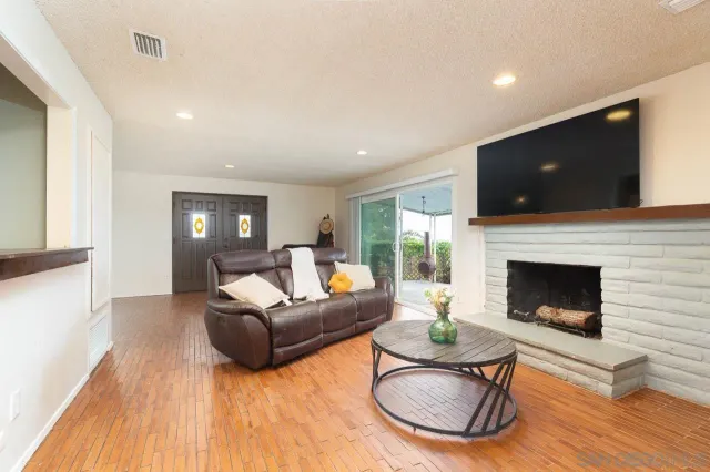 a living room with furniture a flat screen tv and a fireplace