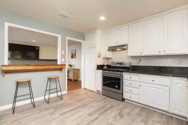 a kitchen with granite countertop white cabinets and white appliances
