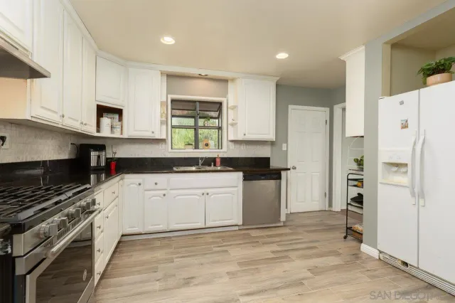 a kitchen with stainless steel appliances a refrigerator sink and cabinets