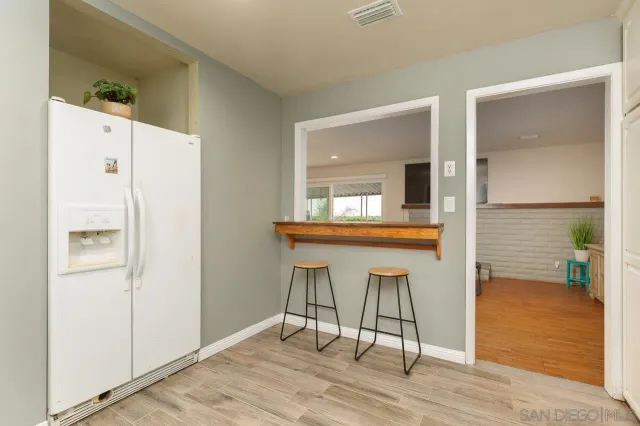 a view of kitchen with wooden floor electronic appliances and window