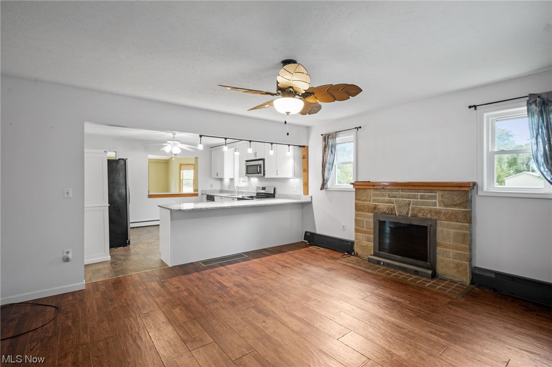 228 Cavalry Road Vermilion, OH 44089 - Photo 9 of 34 Kitchen featuring a wealth of natural light, range, light countertops, ceiling fan, and dark hardwood flooring