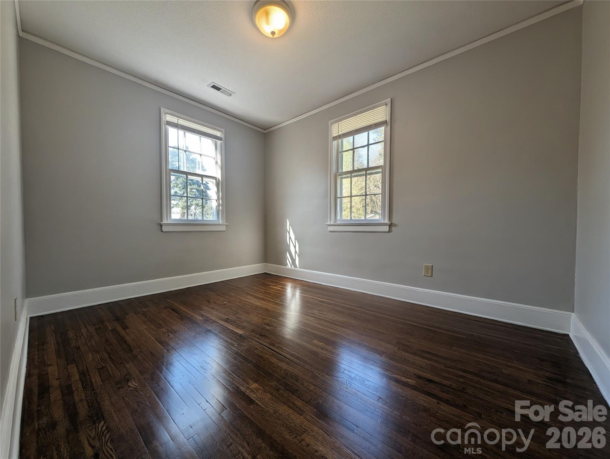 118 Brown Street Lake City, SC 29560 - Photo 8 of 12 a view of an empty room with wooden floor and a window