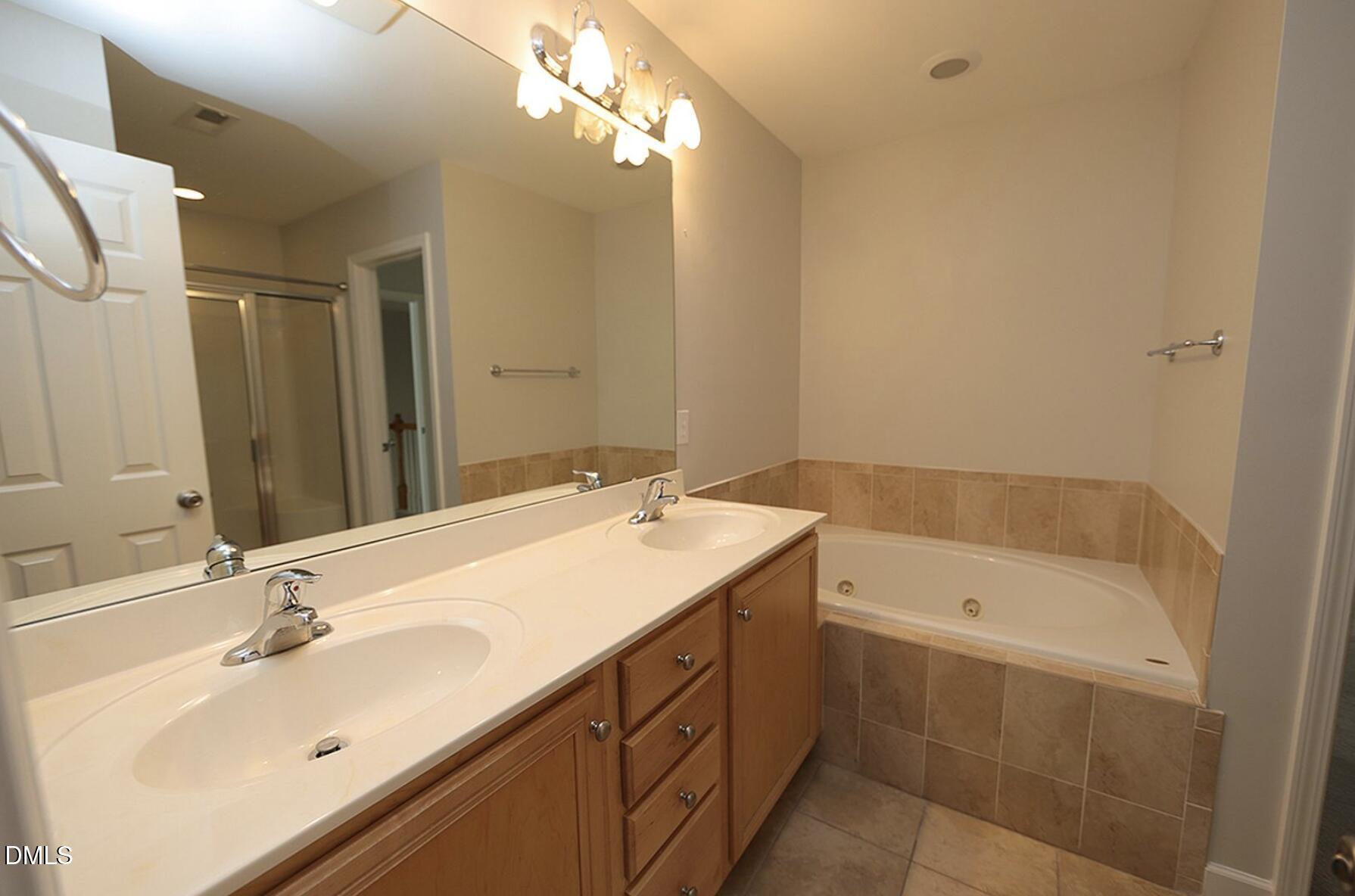 5947 Four Townes Lane Raleigh, NC 27616 - Photo 8 of 13 a bathroom with a sink double vanity granite tub shower and a mirror