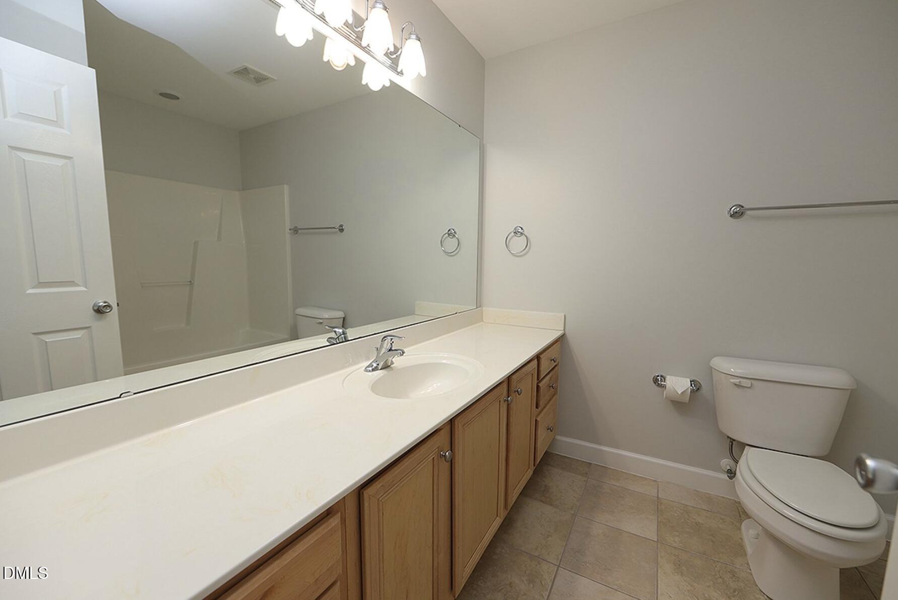 5947 Four Townes Lane Raleigh, NC 27616 - Photo 10 of 13 a bathroom with a toilet a sink and mirror